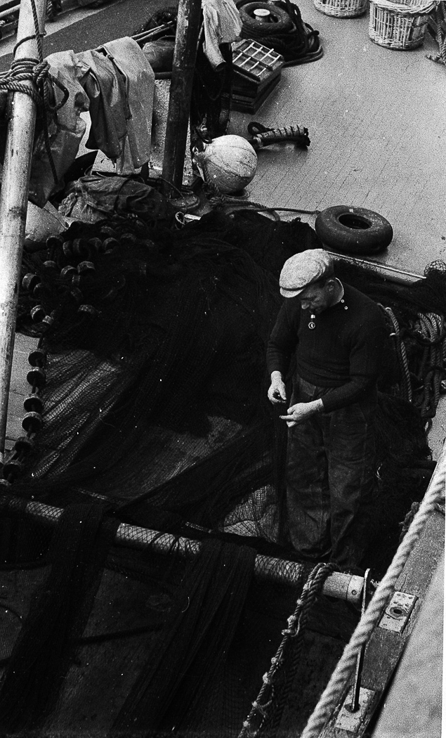 Michael Fairnie repairing a ringnet onboard 'Achates', LH232, Isle of Man, 1950.