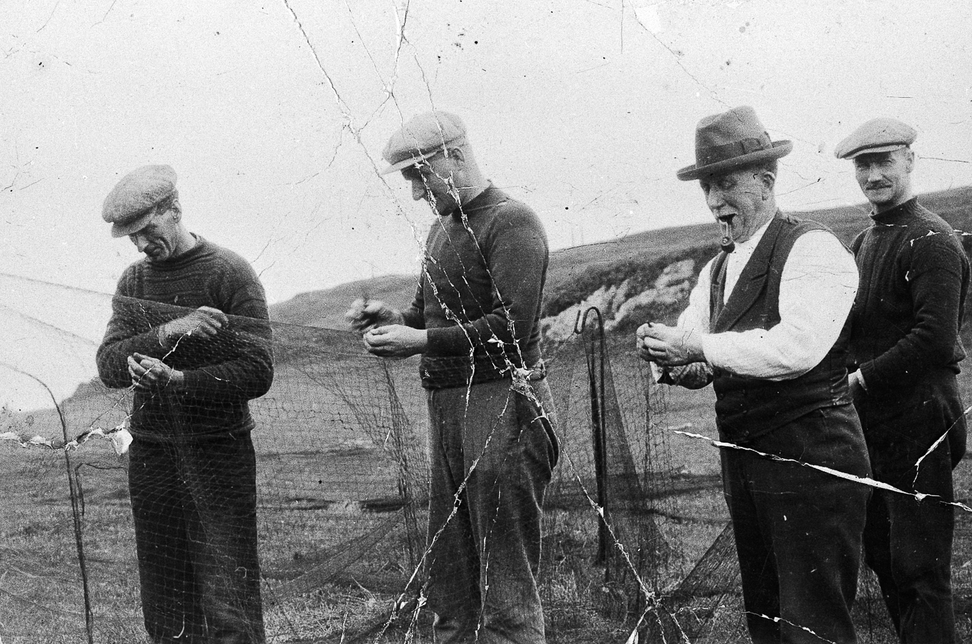 Crew of 'Theresa' mending a ringnet, Carradale. L-R: Donald Mitchell, John Galbraith, James Conley, and Lachlan Patterson.