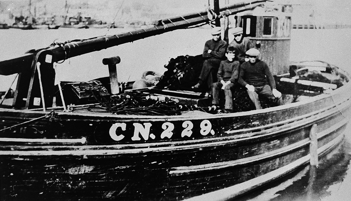 Crew onboard 'Bengullion', CN229. Campbeltown. This boat was crewed by the Blair family of Campbeltown. Back row, L-R: Willy Blair, Sandy Blair Front row, L-R: 'Young Dougal', unknown - possibly Archie or Malcom Blair, who were twins.