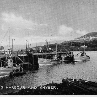 Postcard entitled 'Mallaig Harbour and Khyber' showing boats in the harbour. Boats pictured, L-R: 'Stormdrift II', BA364, 'Frigate Bird', TT117, 'Silver Fern', BA101, and 'Silver Lining', BA102.